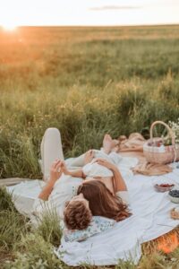 Picnic Engagement Photos in a Field During Golden Hour