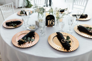 Black, white, and gold color scheme on wedding reception tables.