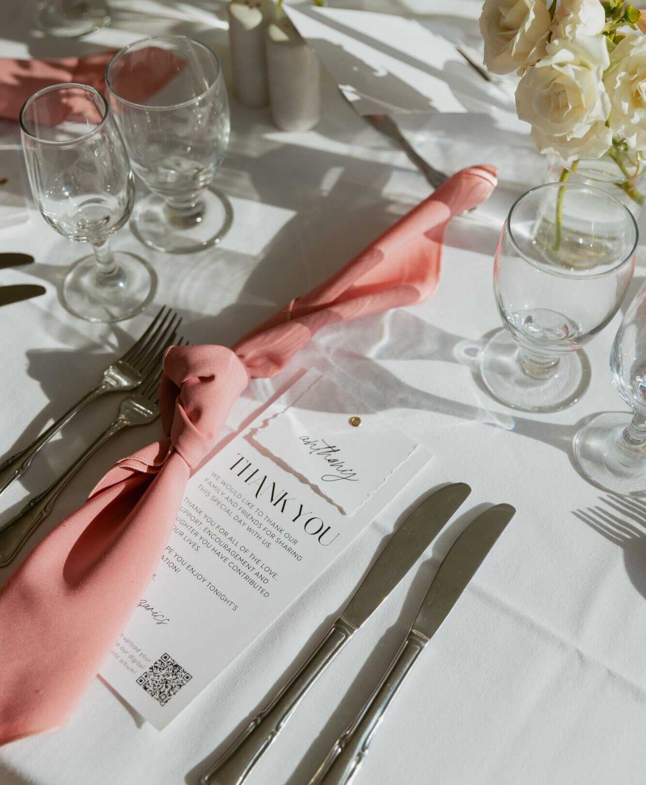 A mauve pink knot style wedding napkin fold on a reception table.