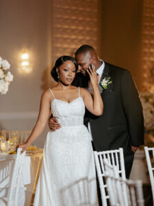 Bride and groom pose in ballroom