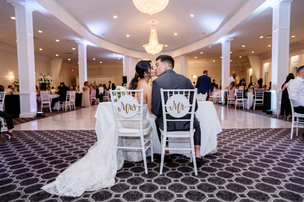Avenir | Bride and Groom Kissing at Sweetheart Table