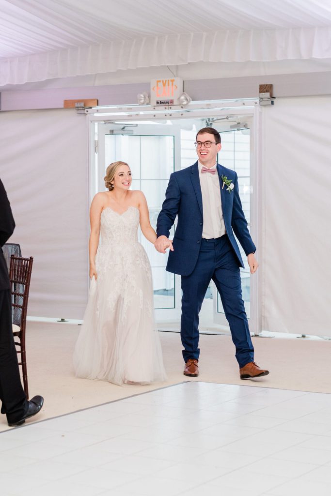 Bride and groom entering their reception in the tent at The Villa.