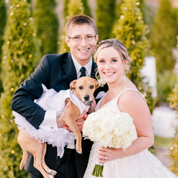 Bride and Groom Holding Their Dog Dressed Up For Wedding