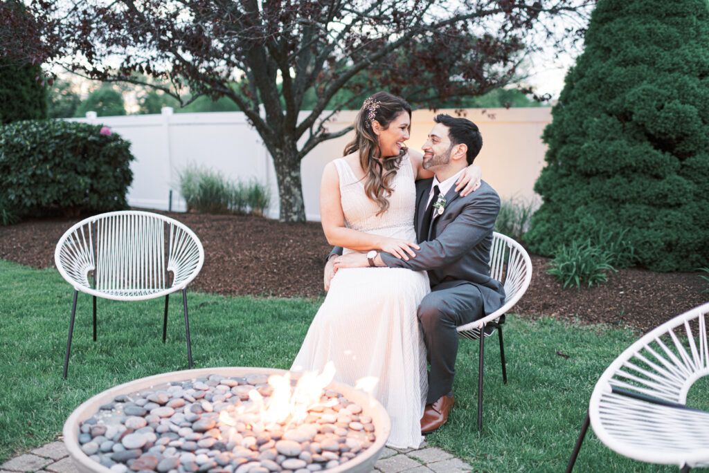 Bride and Groom Sitting at Outdoor Firepit at The Tent at The Villa