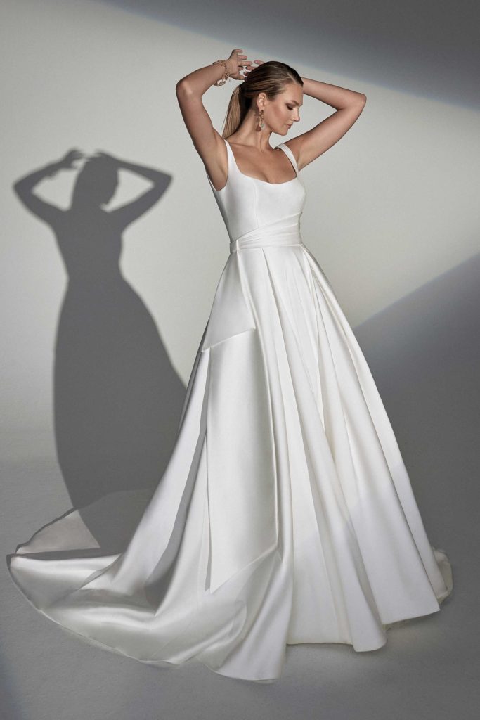 Bride modeling a 2023 Justin Alexander wedding dress with clean sleek lines