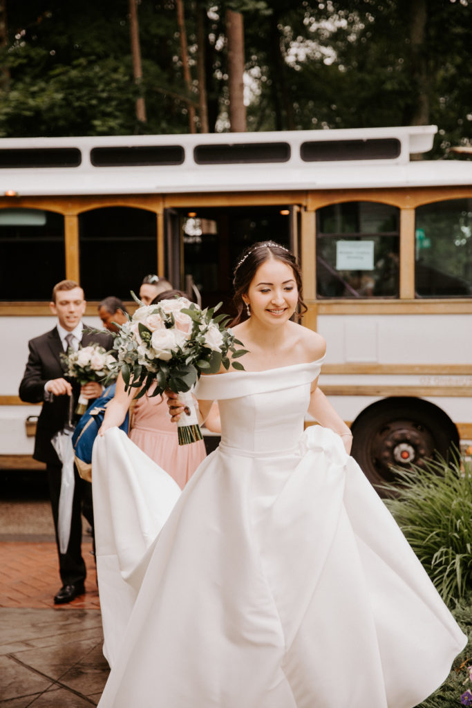 Couples often forget to include transportation as a wedding budget item like this bride in front of a trolley