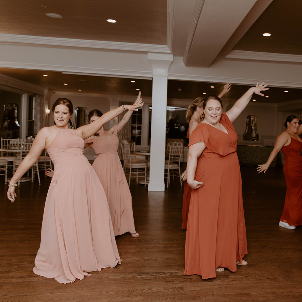 Bridesmaids dancing to a wedding reception entrance song with a choreographed routine