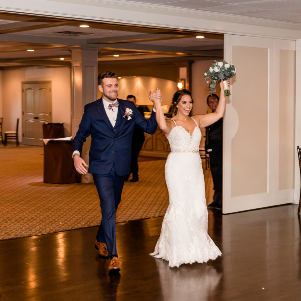 Bride and groom walk into wedding reception for the first time as a married couple