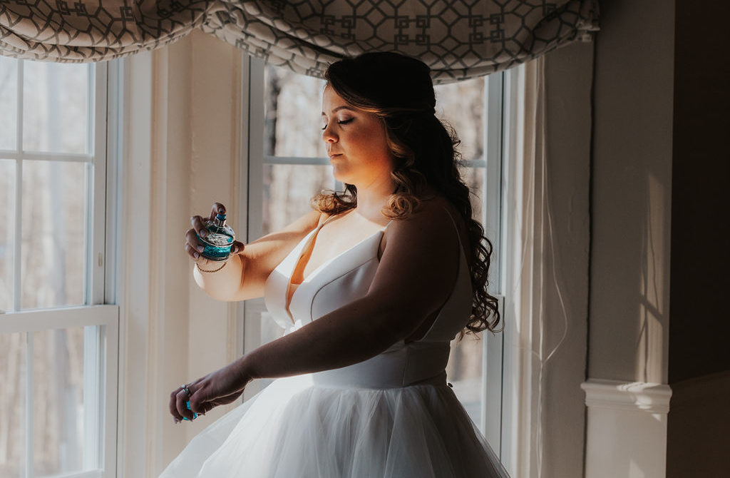 Bride sprays her wedding day perfume before walking down the aisle