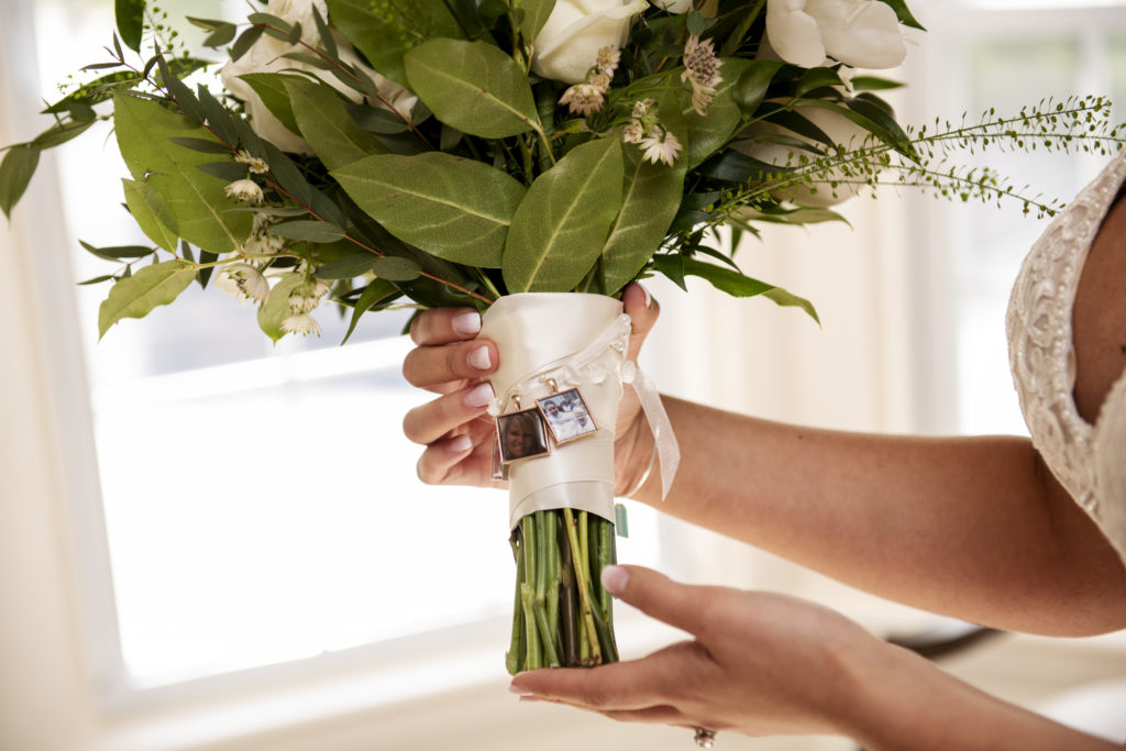 Something old wedding tradition honoring loved ones on bridal bouquet