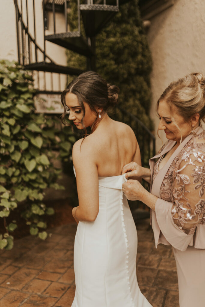 Mom helps bride get ready before ceremony at The Villa in East Bridgewater, Massachusetts