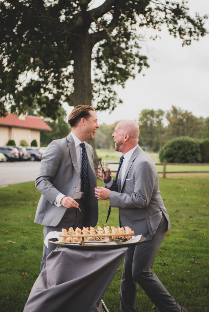 Groomsmen laughing during cocktail hour at The Villa in East Bridgewater, Massachusetts