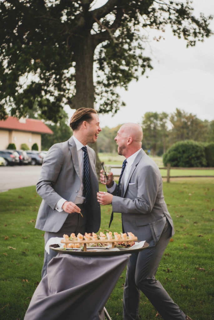 Groomsmen laughing during cocktail hour at The Villa in East Bridgewater, Massachusetts