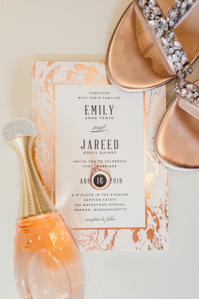 Wedding stationary details with perfume, jewelry, and shoes