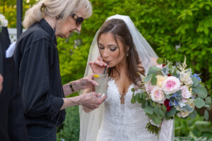 bridal attendant helping bride with her drink
