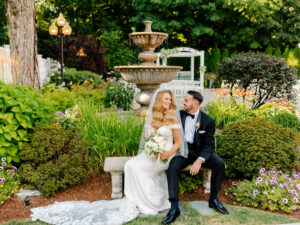 Bride and Groom Sitting in Front of Fountain at Saphire Estate
