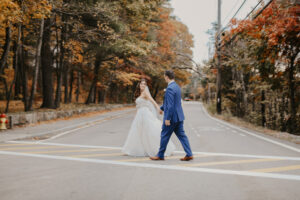 Bride and Groom Cross the Street in Autumn