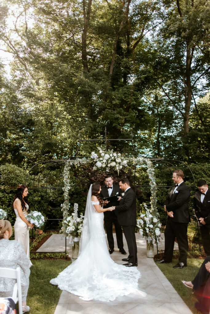 Bride and Groom Hold Hands During Outdoor Wedding Ceremony