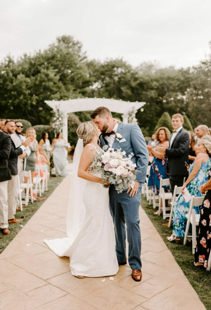 Bride and Groom Kiss in Aisle at The Tent