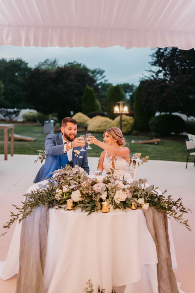 Bride and Groom Toast at Sweetheart Table
