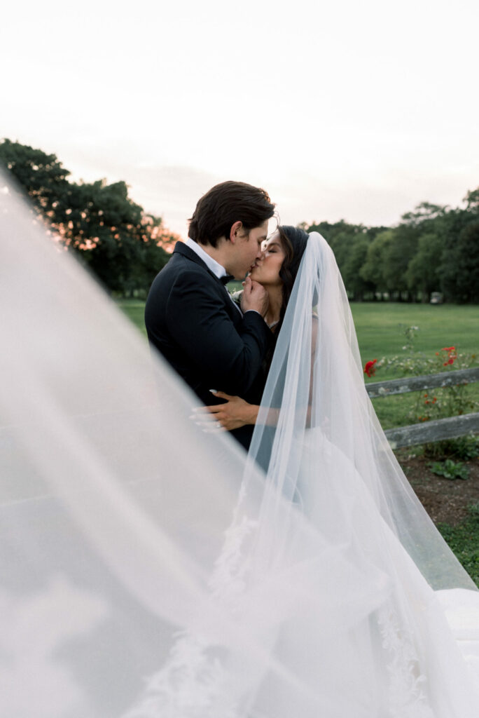 Bride and Groom Kissing in Field