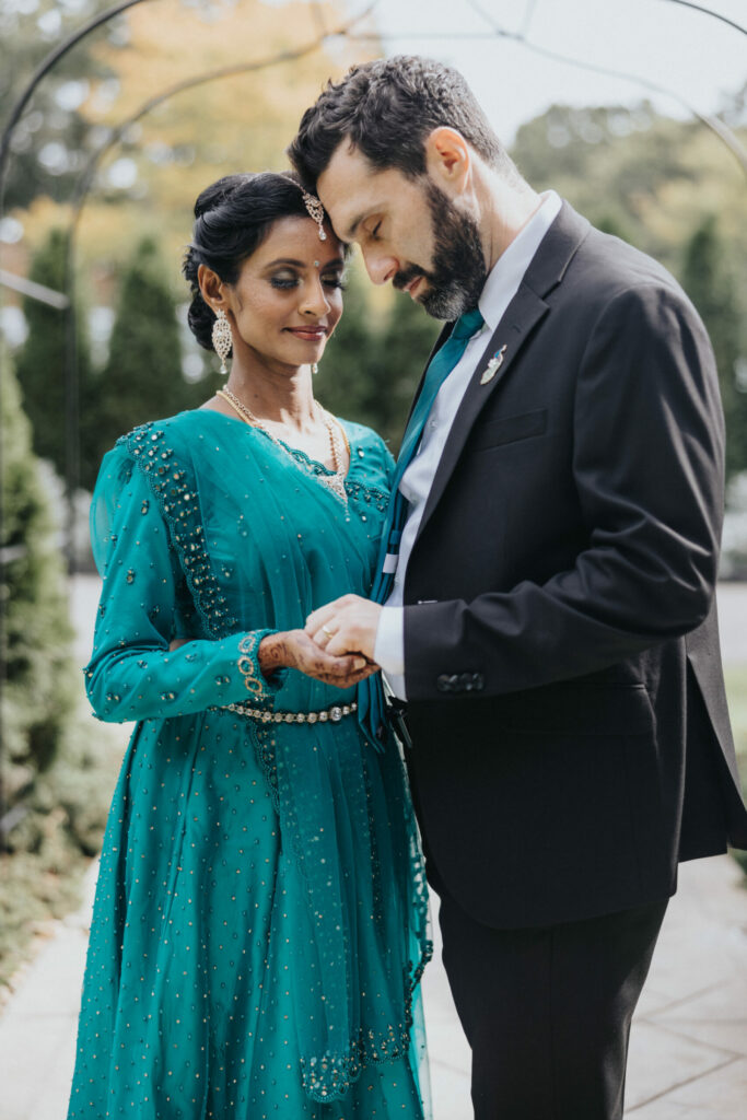 Bride in Blue Sari and Groom in Suit Hold Hands at Avenir