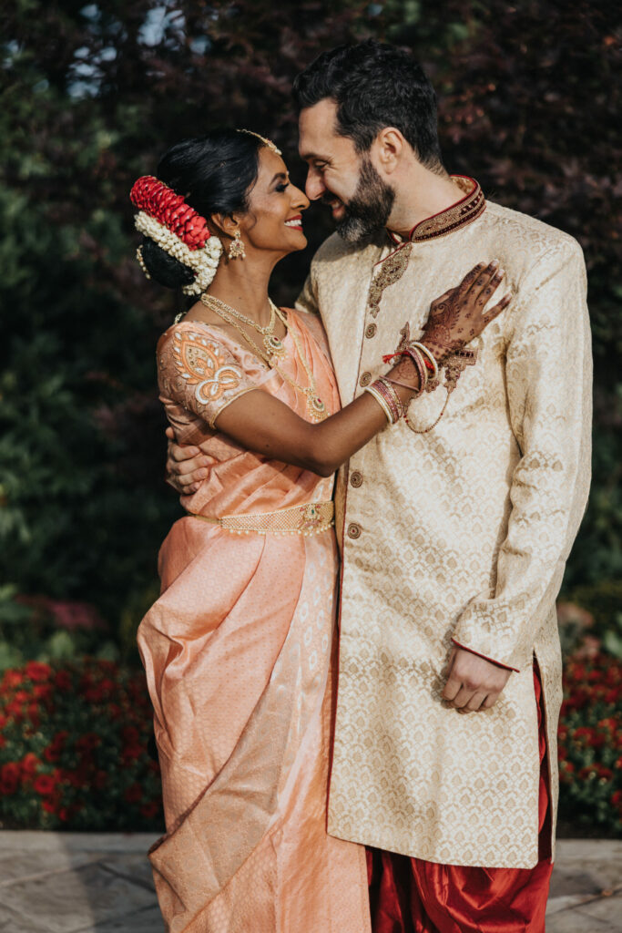 Bride and Groom Wearing Peach Sari and Beige Sherwani Embrace at Avenir in Walpole