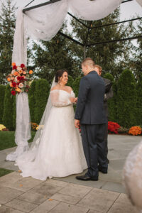 Bride and Groom Outdoor Ceremony with Orange and Red Flowers at The Villa in East Bridgewater Massachusetts