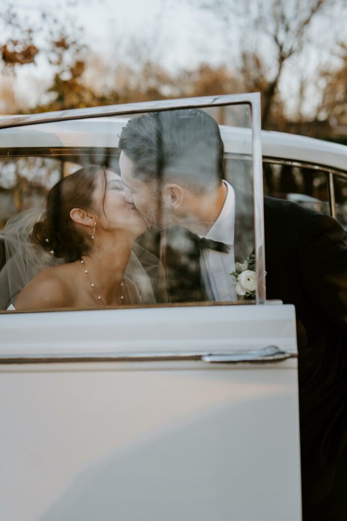 Bride and Groom Kissing Through Car Window of Vintage Rolls Royce at Saphire Estate