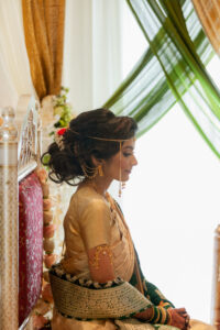 Indian Bride Sits During Traditional Indian Wedding Ceremony With Green and Gold Draping
