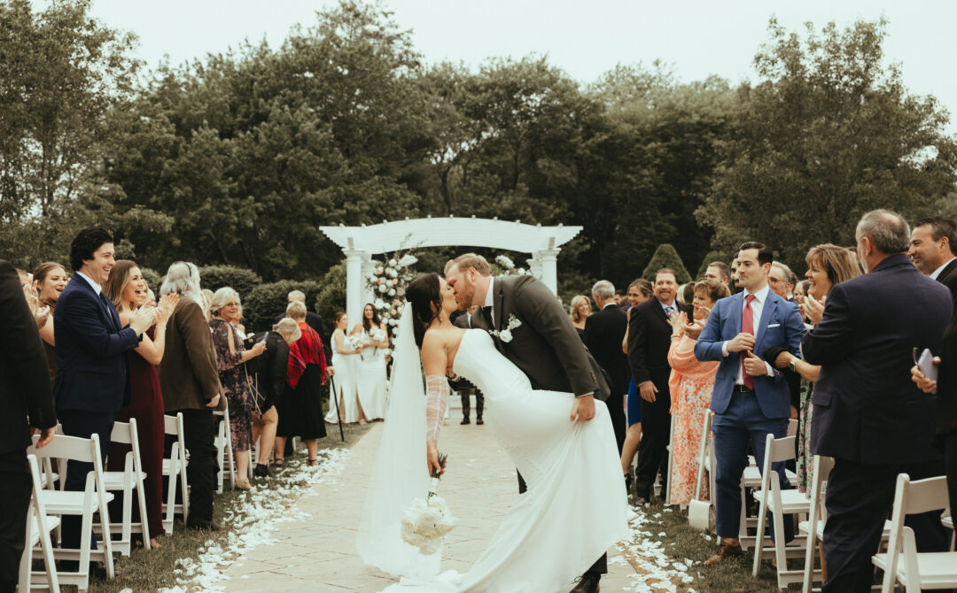 Bride and Groom Romantic Dip Kissing in Aisle After Ceremony