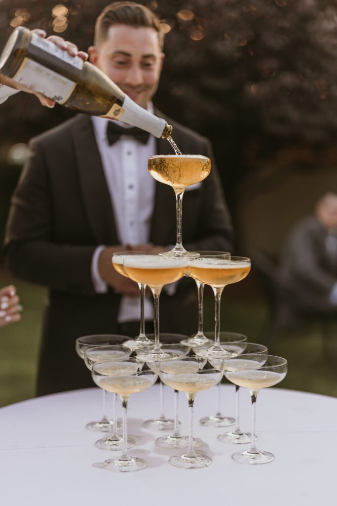 Groom and Champagne Tower Champagne Pour