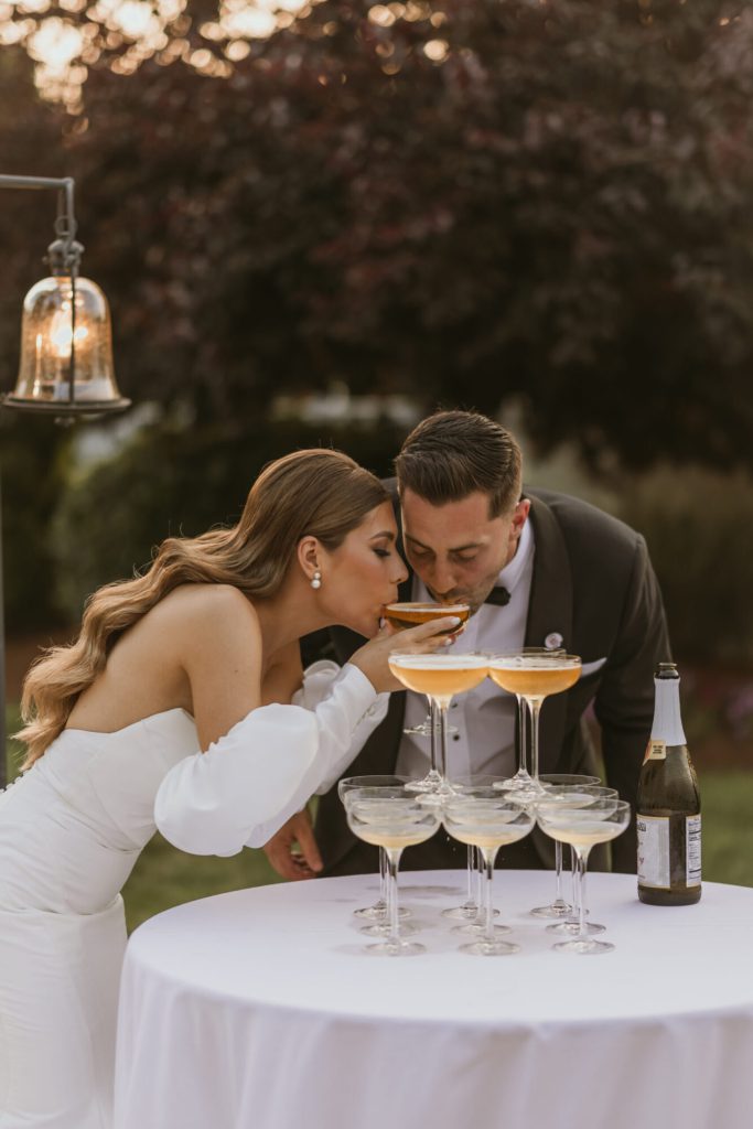 Bride and Groom Sipping From Champagne Tower