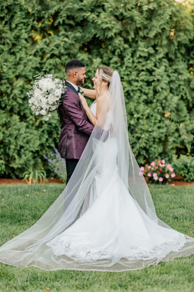 Bride and groom Portrait Against Greenery Veil Spread