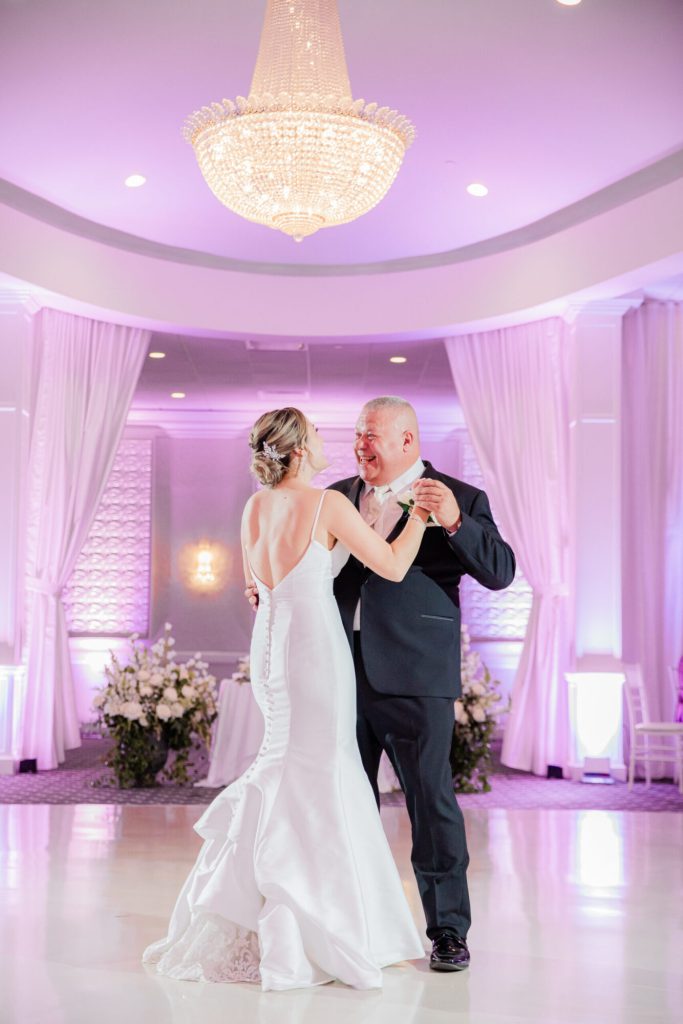 Father Daughter Dance under Chandelier In Ballroom