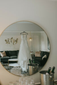 Round Mirror Reflection of Dress Hanging in Saphire Estate Wedding Suite 