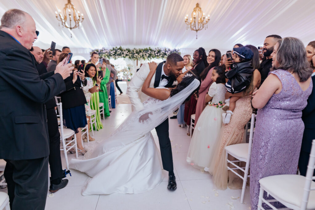 Bride and Groom Dip Kiss During Indoor Ceremony