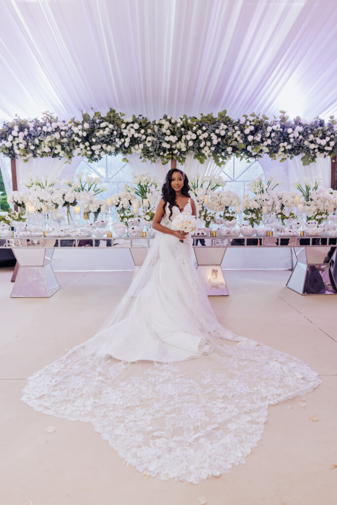 Bridal Portrait Cathedral Veil in Front of White Floral Display