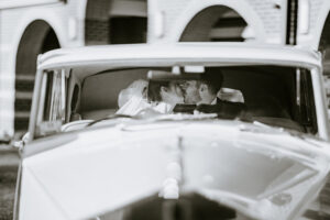 Bride and Groom Black and White Portrait Kissing in the Back of a Vintage Rolls Royce