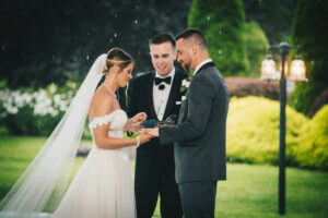 Bride and Groom Exchanging Rings Rainy Indoor Tent Ceremony 