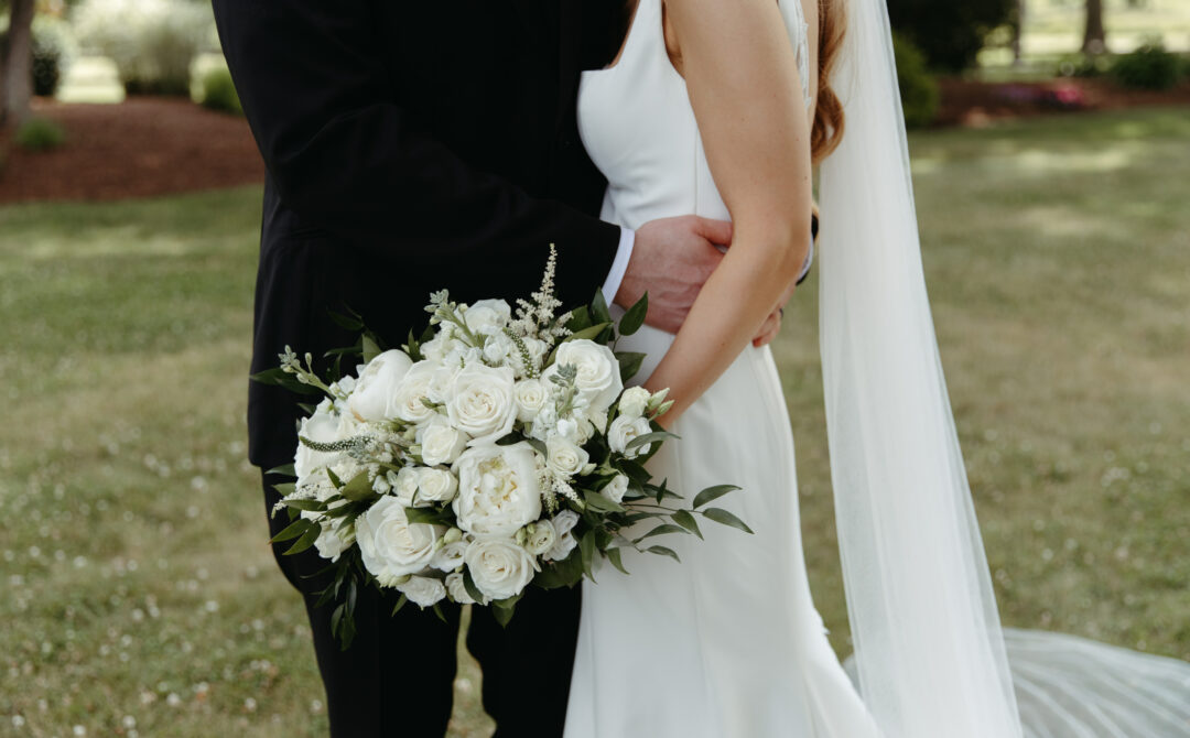 Bride and Groom Hands Around Waist Focus on White Bouquet