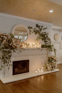 Fireplace decoration for cozy winter wedding with candles and florals