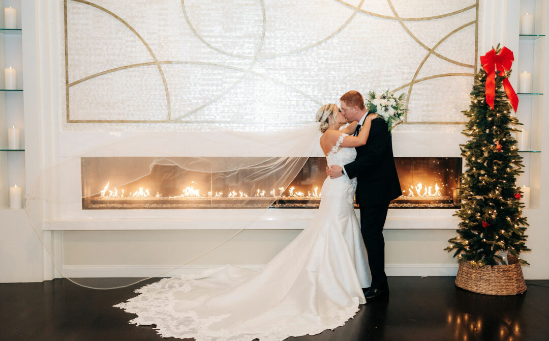 Winter Wedding Couple Kissing In Front of Fireplace