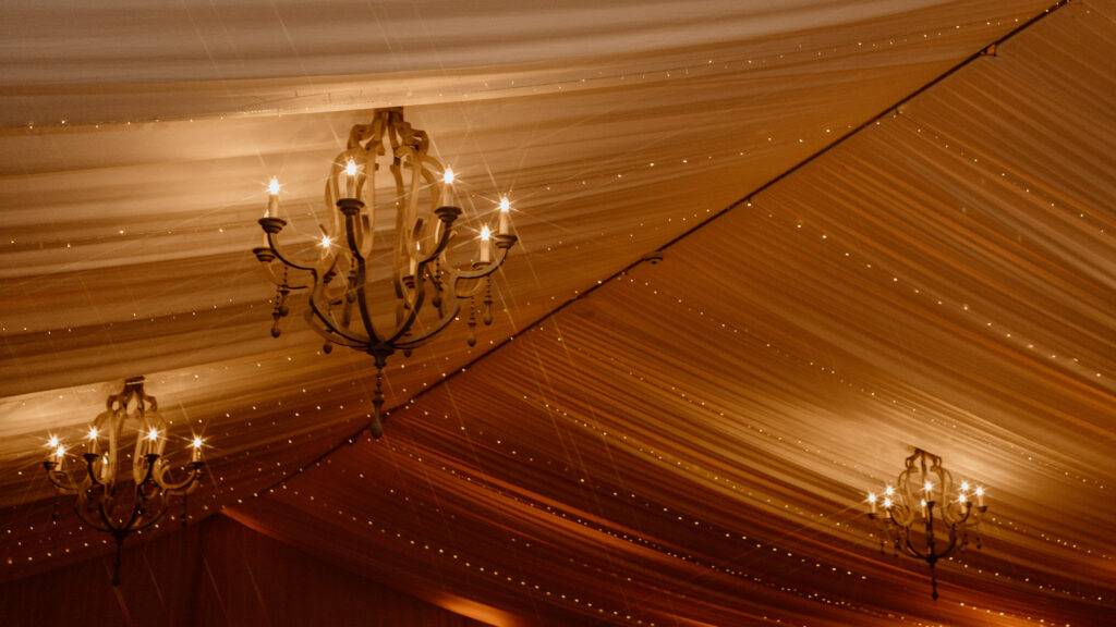 Romantic wedding light trend of twinkle lights and chandeliers in tent