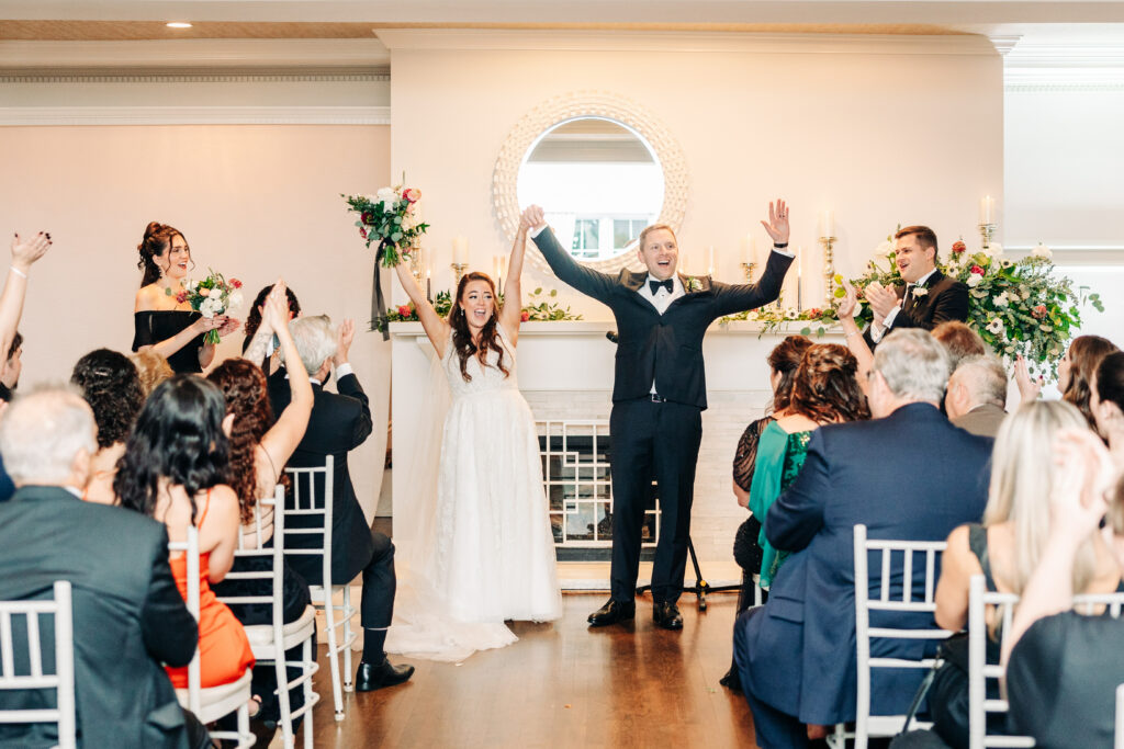 Bride and Groom Hands Up Indoor Ceremony Recessional