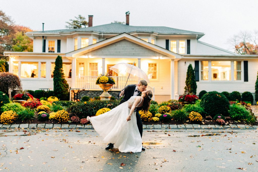 Bride and Groom dip Kiss in Front of Glowing Saphire Estate