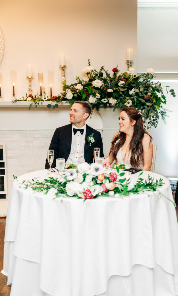 Bride and Groom at Sweetheart Table in Front of Fireplace