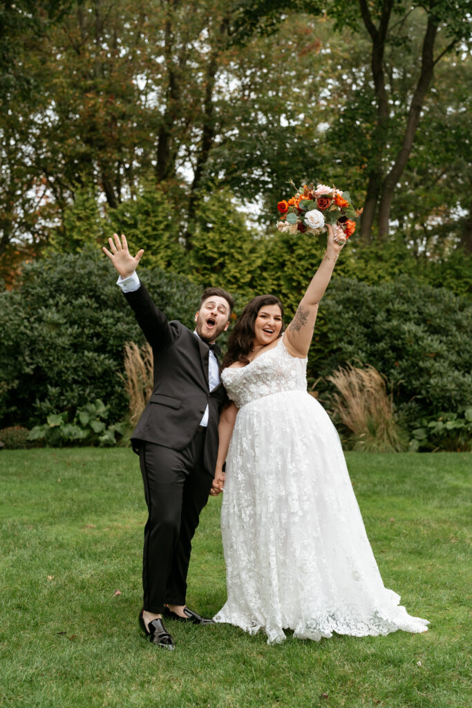 Bride and Groom Hands up Outside in October