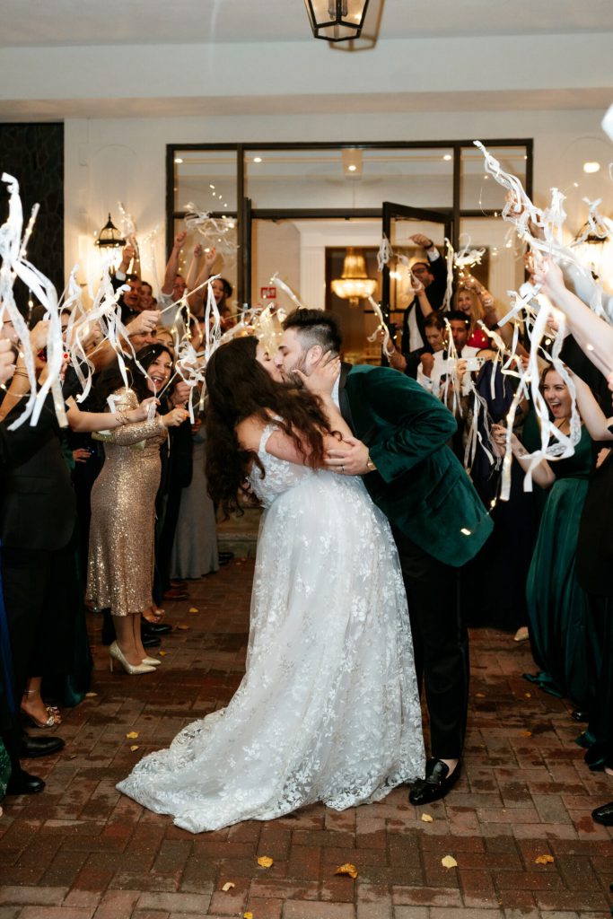 Bride and groom at avenir wedding send off with streamers