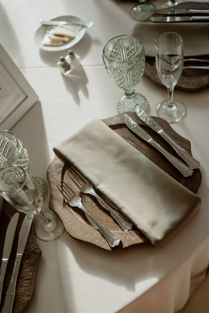 Place setting with a taupe napkin and green glassware.